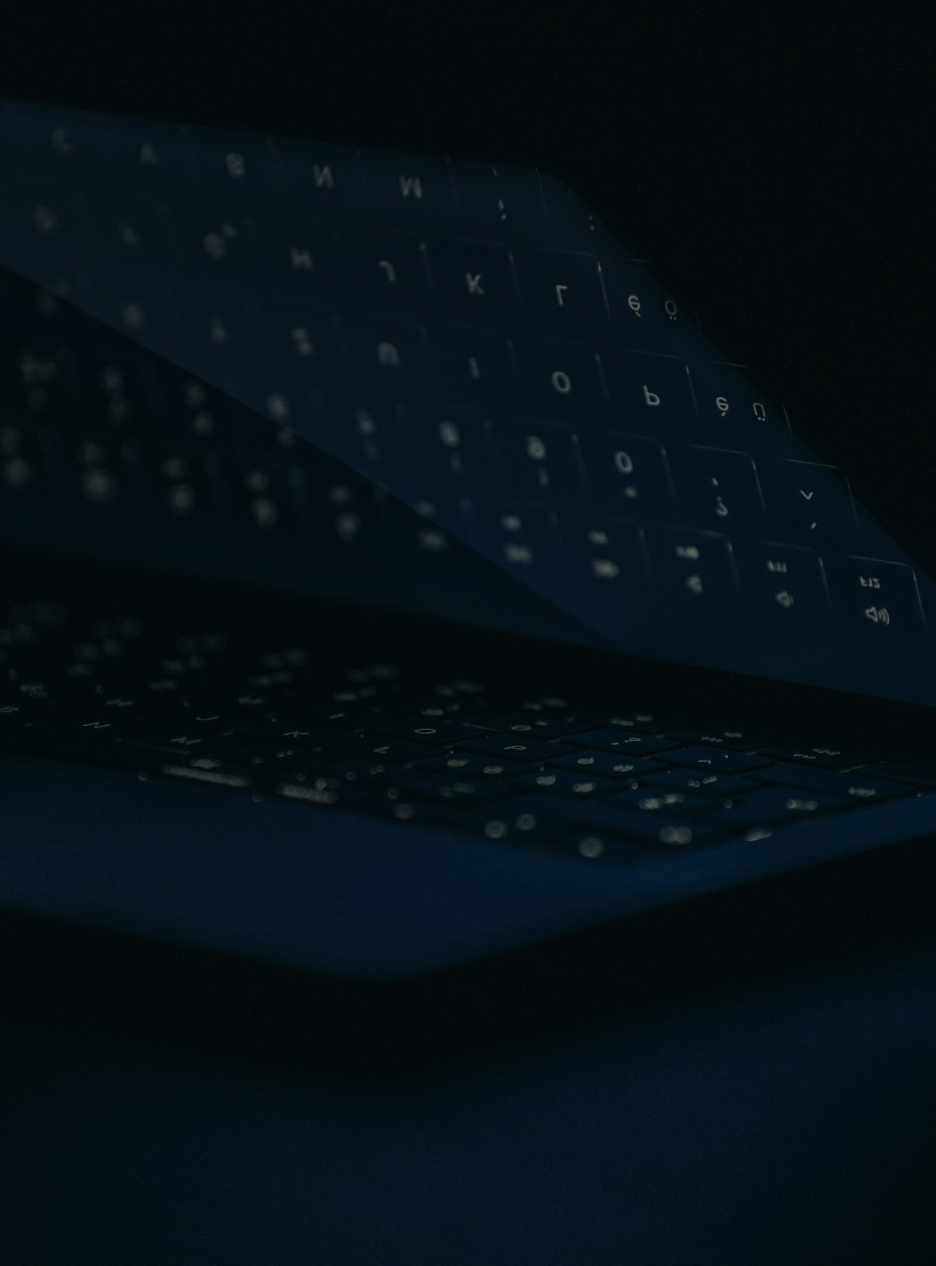 Dark laptop with glowing Cyrillic keyboard overlay